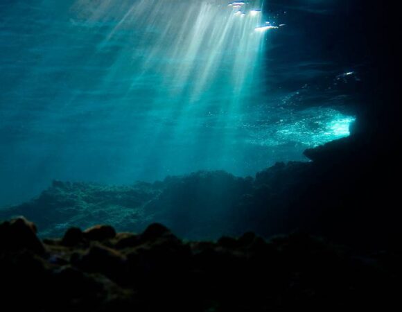 Underwater scene with god rays shining down from surface